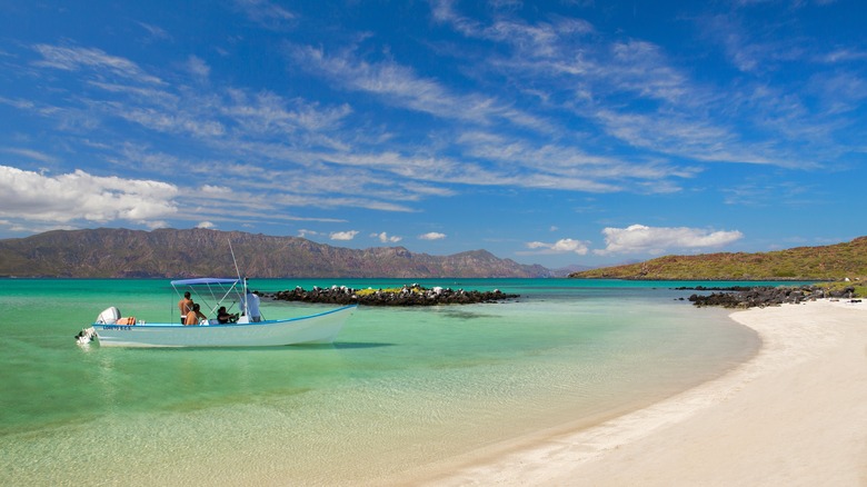 Une plage de sable blanc avec bateau