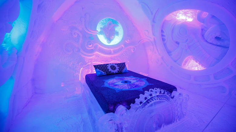 Lit simple dans une suite de couleur violette à l'Hôtel de Glace