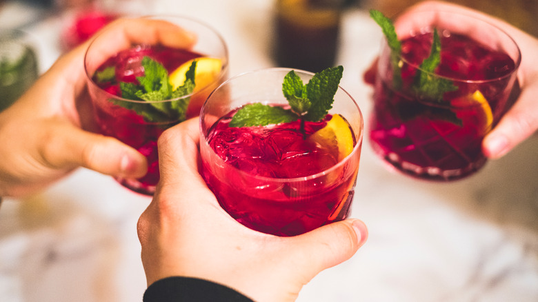 Les gens trinquant avec des verres de sangria