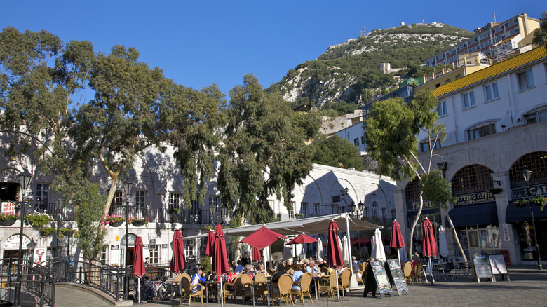 Restaurant avec terrasse extérieure au pied de gros rocher entouré d'arbres