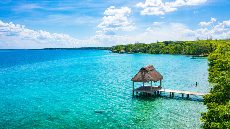 Palapa sur un ponton dans les eaux turquoise du lac Bacalar