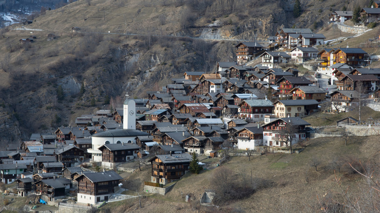 Chalets en bois et clocher de l'église moderne dans le village d'Albinen, Suisse