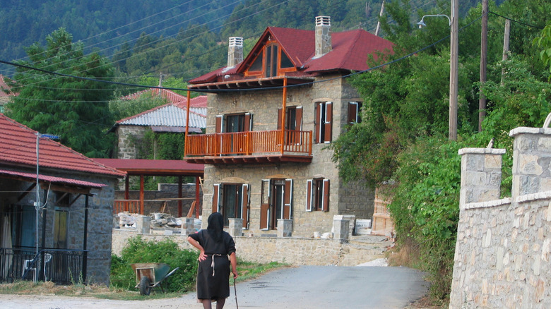 Une femme marche dans le village calme d'Ano Chora