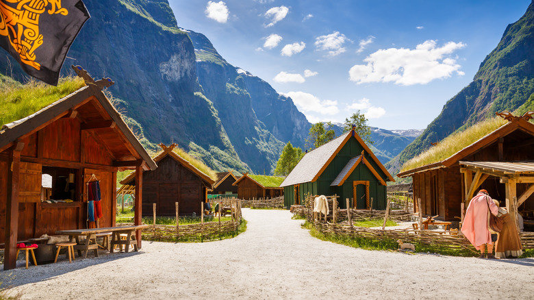 Un village de Viking traditionnel sur un fond de montagnes et un ciel bleu.