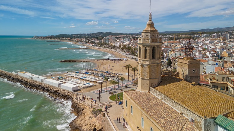 Une vue aérienne en regardant le clocher de l'église Sitges et des kilomètres de plages