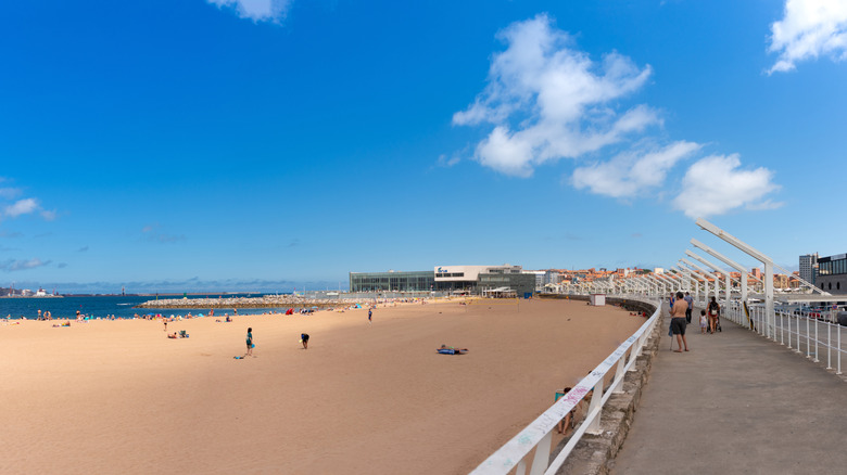 Une vue de la large plage de sable de poniente et de la promenade à Gijón Espagne