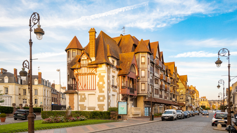 Old Architecture à Deauville, France, avec des voitures qui tapissent la rue, les lampadaires le long de la route et de l'architecture européenne