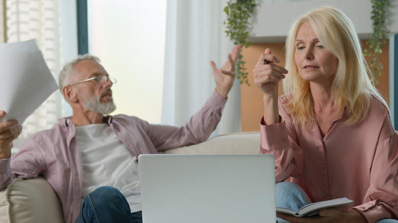 Un couple frustré devant un ordinateur portable