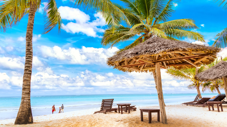 Sun-chouette, parapluies et paumes sur la plage de Diani, Kenya, Afrique