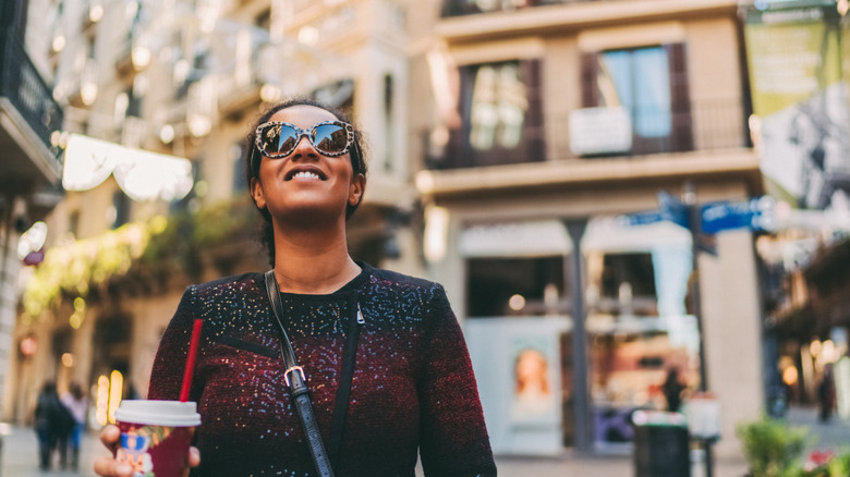 Femme souriante tenant un verre en Espagne