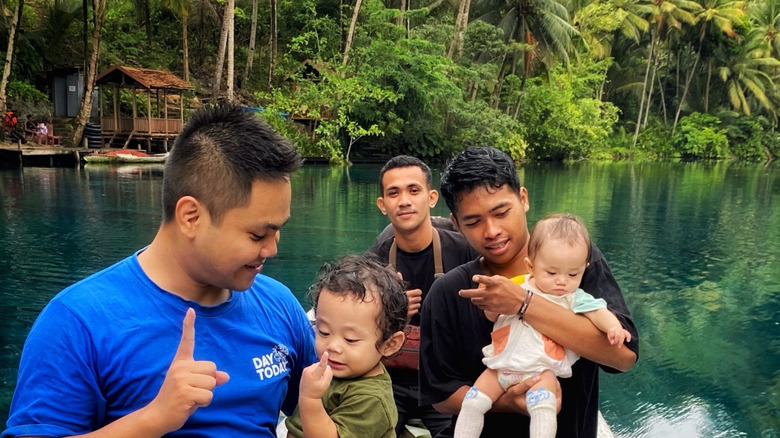 Hommes et leurs enfants sur un petit bateau sur le lac Paisu Pok