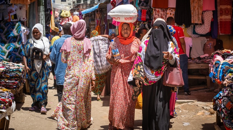 Des femmes et des hommes modestement habillés dans un marché à Zanzibar