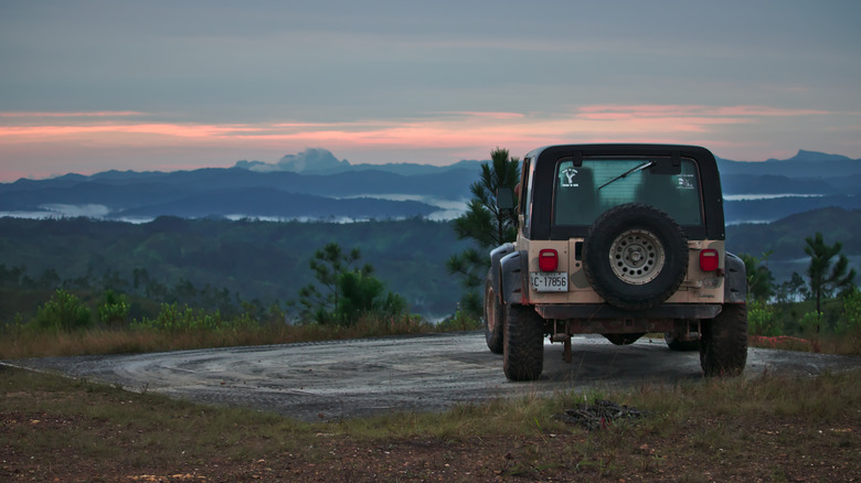Jeep garé sur une crête surplombant la forêt de crête de pins de montagne