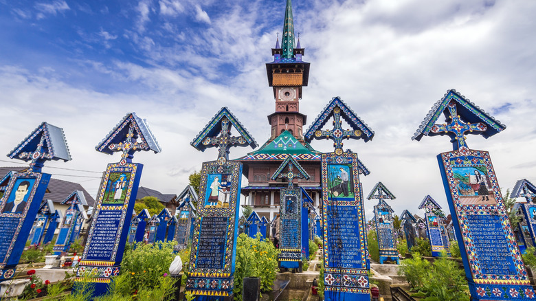 Croix peintes en bois et église dans le joyeux cimetière, Roumanie
