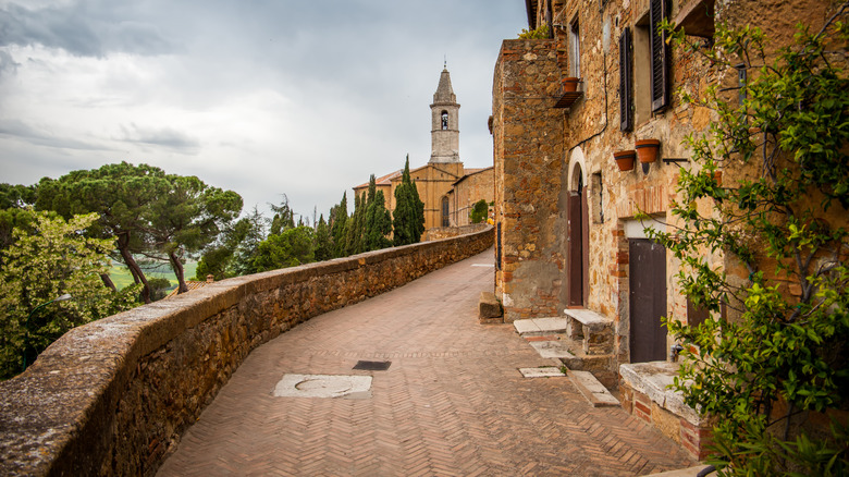 Vieux murs médiévaux et rues étroites avec un clocher à Montalcino