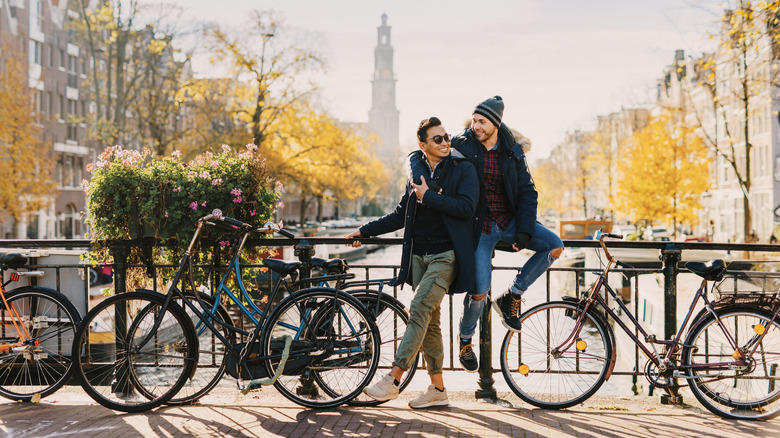 Deux hommes embrassant pour une photo devant les canaux à Amsterdam