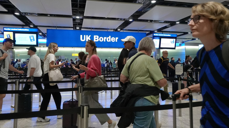 Une ligne de personnes entrant dans la frontière britannique de l'aéroport.
