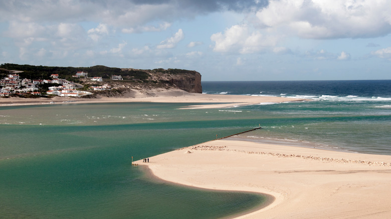 Une plage de sable dépassant dans une mer sur la côte du Portugal
