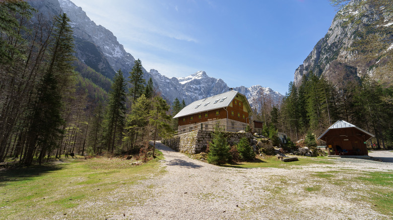 Montagnes entourant des cabines dans une forêt du parc national Triglav, Slovénie