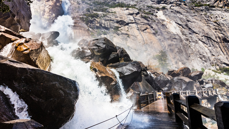 Une cascade monte sur un pont en bois