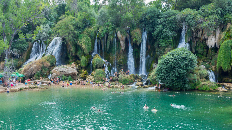 Les gens nagent dans la cascade de Kravica en été