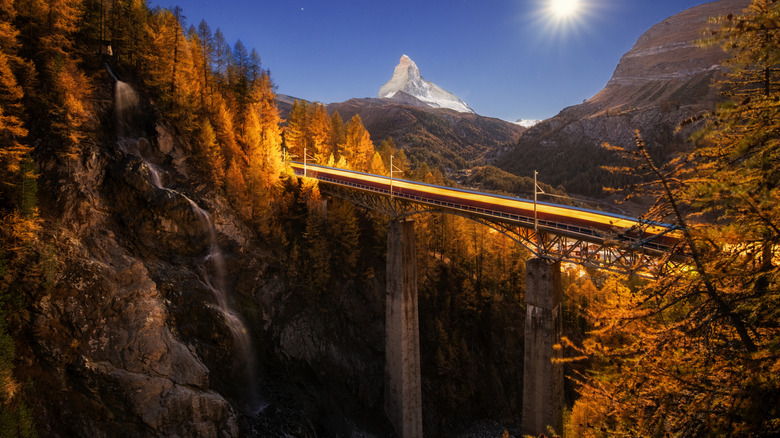 Trains traversant un pont en Suisse la nuit pendant l'automne