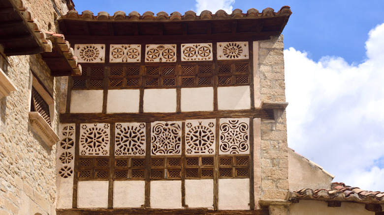 Un mur avec des fenêtres avec des formes décoratives dans le village de Mirambel en Espagne