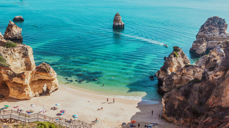 Petite plage entourée de formations rocheuses calcaires et de l'eau turquoise
