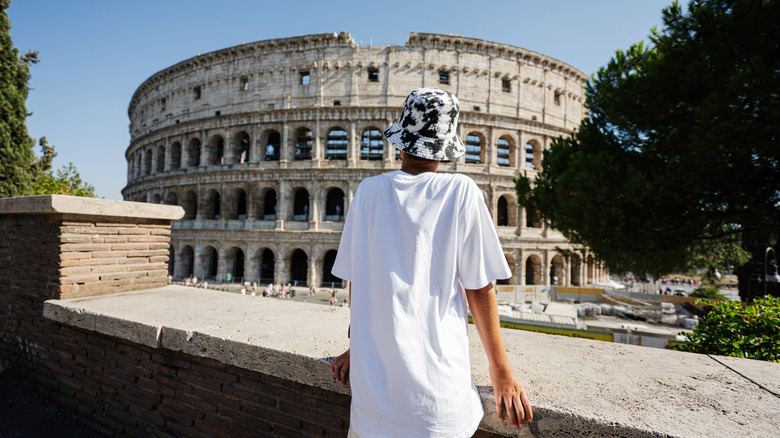 À l'arrière d'un jeune touriste en regardant le Colosseum