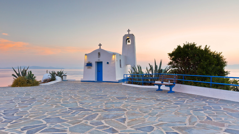 Église grecque bleue et blanche au coucher du soleil