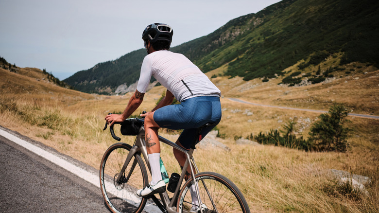 Un cycliste vélo le long de la route transfagarasane dans les montagnes Fagaras