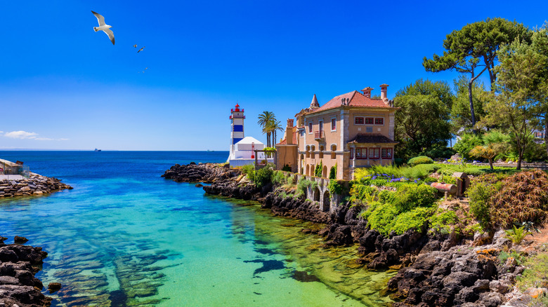 Turquoise Cove surplombant un palais historique et un phare à Cascais, Portugal