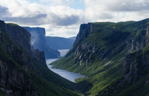 Le lac surréaliste du Canada est un spectacle à couper le souffle du parc national avec des falaises en plein essor et des eaux brumeuses