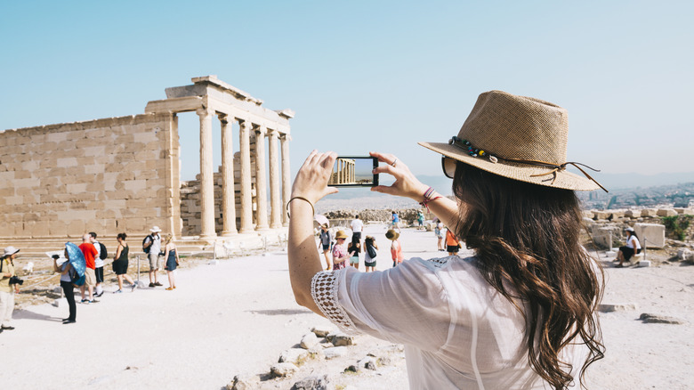 Personne touche et prenant des photos d'anciennes ruines à Athènes, en Grèce,
