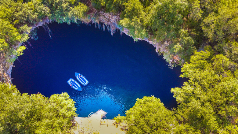 Vue de drones du lac Melissani Cave à Sami, Kefalonie, Grèce, avec des forêts luxuriantes, des eaux turquoise et des bateaux