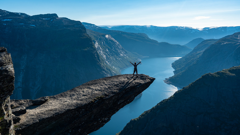 Personne posant sur le rock sur des vues de fjord dramatiques en Norvège