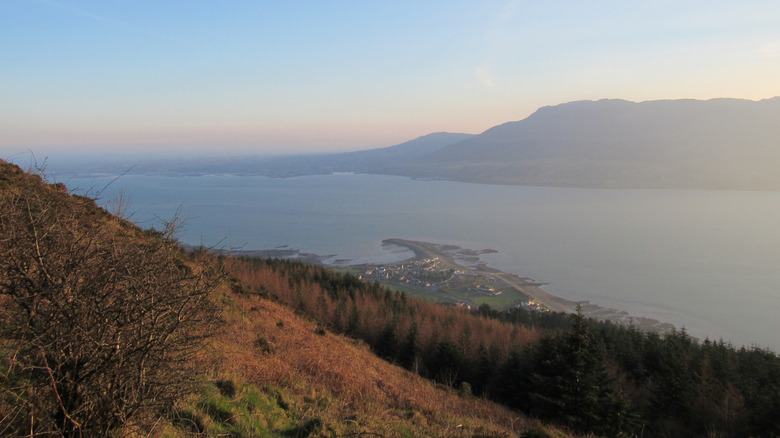 Vue surplombant un lac et une ville avec des montagnes en arrière-plan