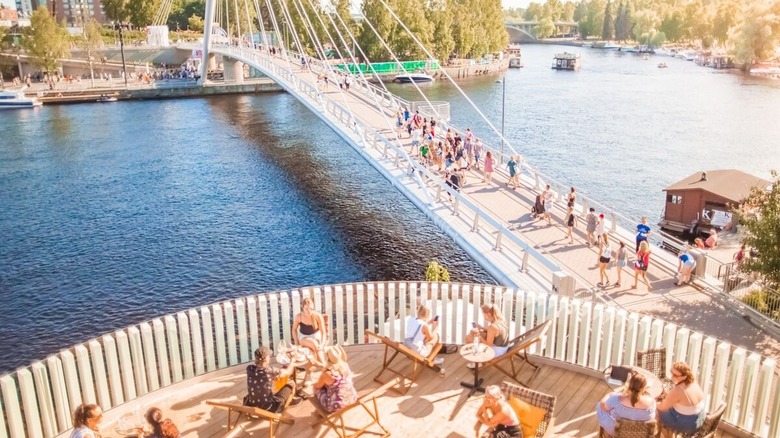 Les gens dînent sur une terrasse et marchent sur Bridge à Tampere, Finlande