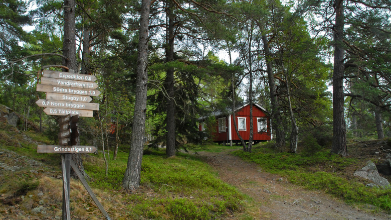 Sacpost et bâtiment rouge dans la forêt sur l'île de Grinda en Suède