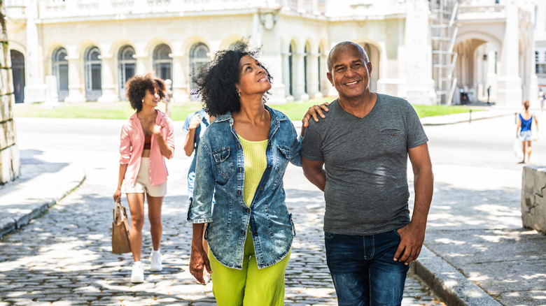 Couple plus âgé marchant dans les rues de La Havane, Cuba