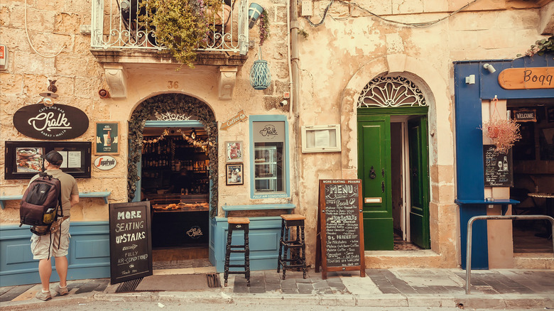Touriste regardant le menu à l'extérieur du restaurant en pierre