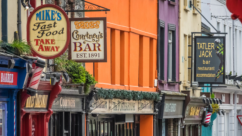 Un gros plan de panneaux de pub et de bâtiments colorés à Killarney, Irlande