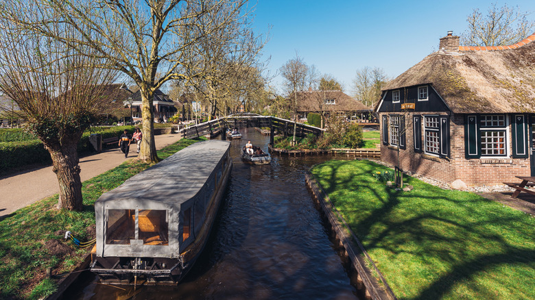 Bateaux sur un canal à côté d'une passerelle à Giethoorn