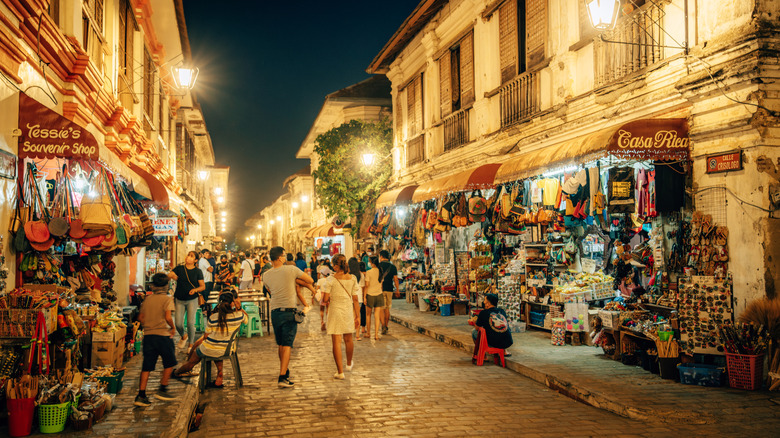 Cobblestone Street avec des vendeurs et des magasins la nuit à Vigan City aux Philippines.