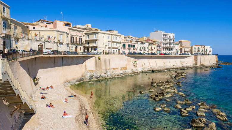 Baigneurs le long de la plage rocheuse d'Ortigia