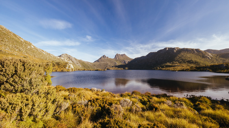 Lac entouré de collines avec une montagne derrière elle
