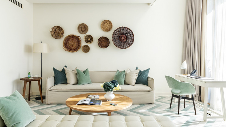 Vue intérieure du salon, y compris un bureau de travail, un canapé et un canapé-lit, de La Maisonette, l'une des suites luxueuses du JW Marriott Venice Resort & Spa, situé sur l'île privée d'Isola delle Rose, photographiée pendant la journée