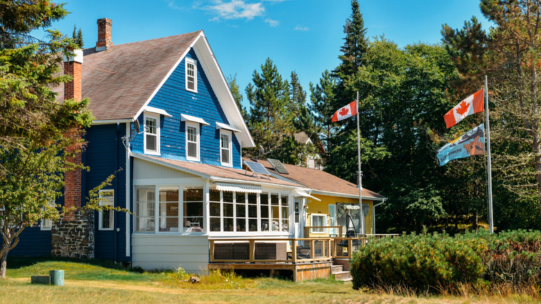 Charmant chalet avec des drapeaux canadiens à l'extérieur