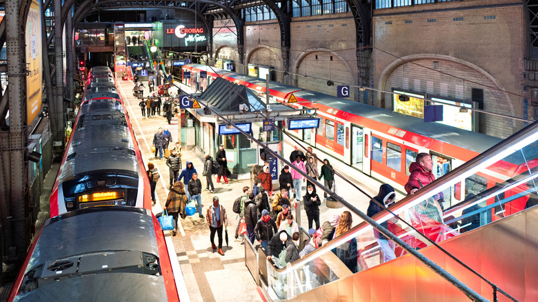 Les passagers débarquent Red Deutsche Bahn Trains et des escaliers mécaniques à Hambourg