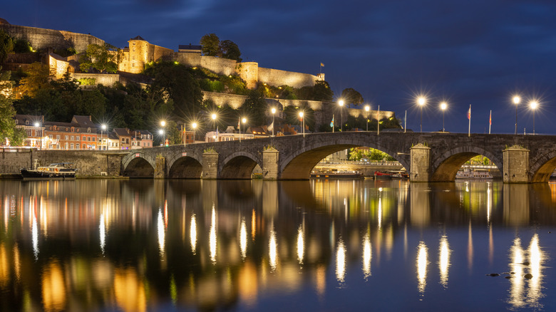 Vue nocturne des lumières se reflétant dans l'eau de Namur Citadel